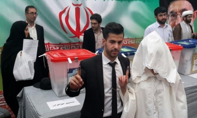 بالصور.. عروسان إيرانيان يدليان بصوتيهما فى الانتخابات الرئاسية الإيرانية