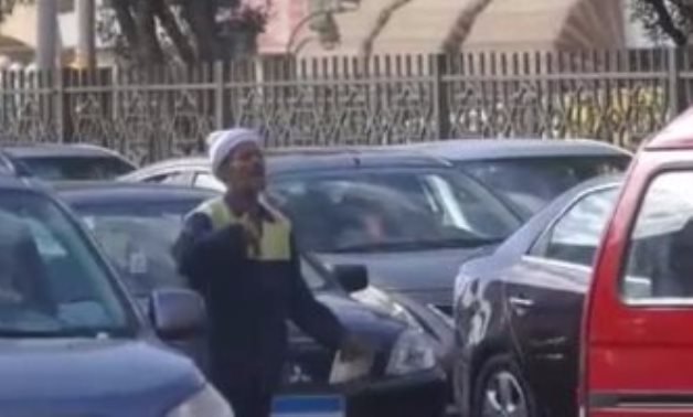 فيديو.. عامل نظافة يؤدى مهام شرطى مرور لتسيير السيارات مطلع كوبرى 15مايو