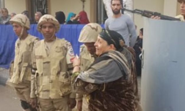صور.. سيدة تقبل رؤوس جنود الجيش بإحدى لجان الدقى: ربنا يحميكم لمصر