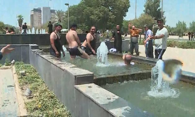 متظاهرون يقتحمون البرلمان العراقي ويستحمون في نافورة المجلس.. صور