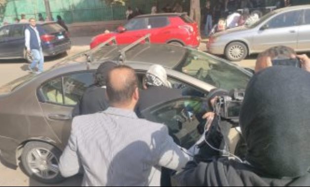 قاضية تتوجه ببطاقة التصويت لناخب من كبار السن داخل سيارته بمصر الجديدة