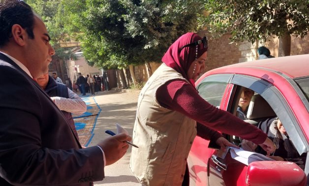حدوتة مصرية.. قاضٍ بلجنة انتخابية يساعد مسنة فى الإدلاء بصوتها داخل سيارتها "صور"