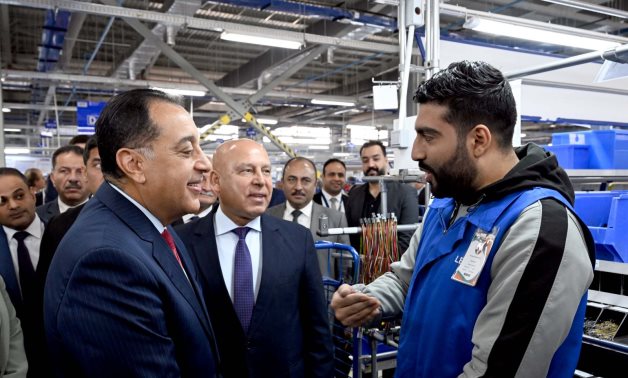 حوار لرئيس الوزراء مع أحد العاملين خلال افتتاح مصنع "ليوني مصر" العالمية لضفائر السيارات بمدينة بدر  