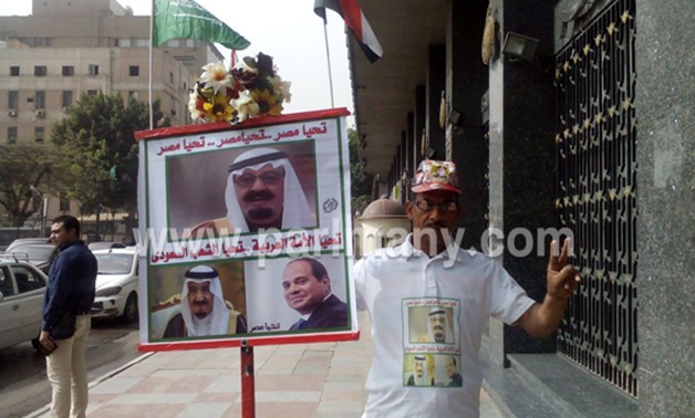 مواطن أمام البرلمان يرفع صورتى الملك سلمان والرئيس عبد الفتاح السيسى