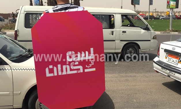 بالصور.. ضبط شاب يتجول فى جزيرة العرب بالمهندسين حاملا لافتة "لِسَّه فى كمان" 