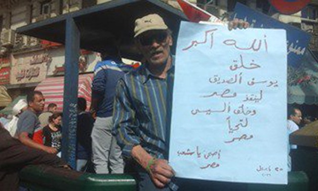 مواطن يرفع لافتة بوسط البلد: "الله خلق يوسف لينقذ مصر.. والسيسى لتحيا مصر"