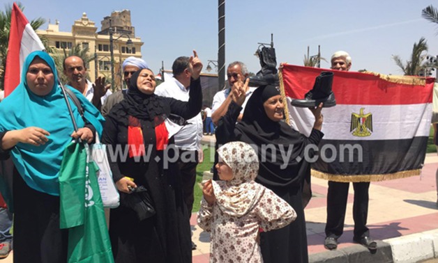 صور اليوم.. سيدة ترفع بيادات الجيش فوق رأسها باحتفالات تحرير سيناء بـ"عابدين"