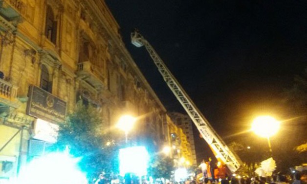 بالصور.. الأمن يحاول منع شاب من الانتحار من على مبنى بميدان عرابى فى الإسكندرية