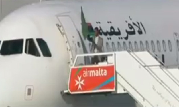 بالفيديو.. أحد مختطفى الطائرة الليبية يلوح بعلم نظام "القذافى" بعد الإفراج عن الركاب