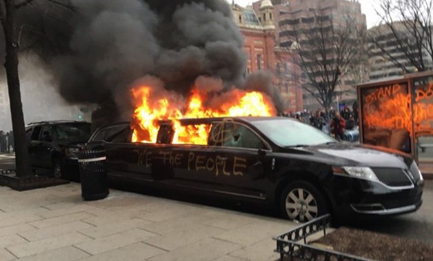 بالصور.. متظاهرون ضد ترامب يحرقون سيارة ليموزين ويكتبون عليها "أحنا الشعب"